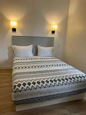 two beds with white pillows in a room at Destination Inn Cache Creek in Cache Creek