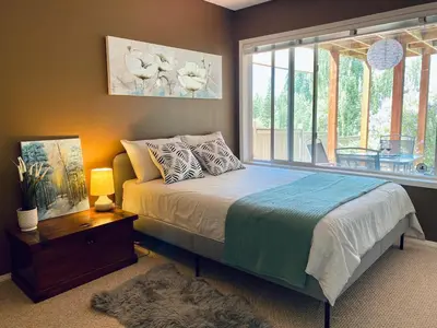 a bedroom with a bed and a large window at Private, Spacious, & Bright Home in Calgary