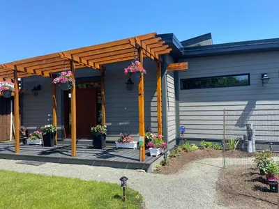 a house with a pergola with flowers on it at EdgeWater Chemainus in Chemainus