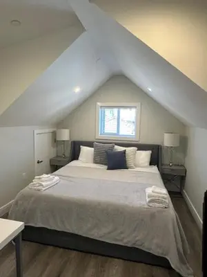 a bedroom with a large bed in a attic at Bright and cozy modern home in Vancouver - central to YVR-Downtown - Free Private Parking in Vancouver