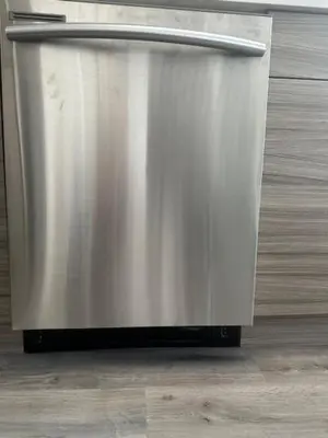 a metal refrigerator sitting on top of a wooden floor at Bright and cozy modern home in Vancouver - central to YVR-Downtown - Free Private Parking in Vancouver