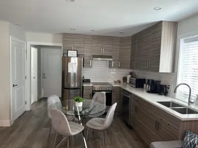 a kitchen with a glass table and chairs in it at Bright and cozy modern home in Vancouver - central to YVR-Downtown - Free Private Parking in Vancouver