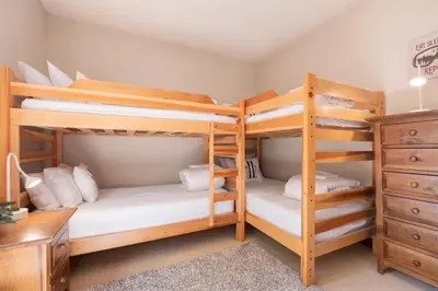 a bedroom with two bunk beds and a desk at Taluswood Bluffs by Outpost Whistler in Whistler