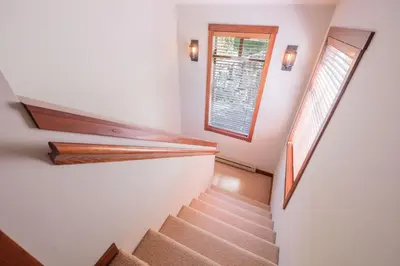 a staircase in a house with a window at Taluswood Bluffs by Outpost Whistler in Whistler