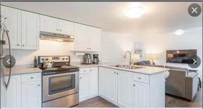 a kitchen with white cabinets and a stove top oven at Cosy country mobile home on 18 acres farm sleeps 5 in Port Alberni