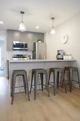 a kitchen with four stools at a large counter at Enchanted Mountain Getaway in Canmore