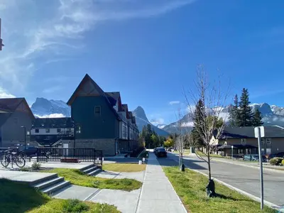 a street in a town with mountains in the background at Enchanted Mountain Getaway in Canmore