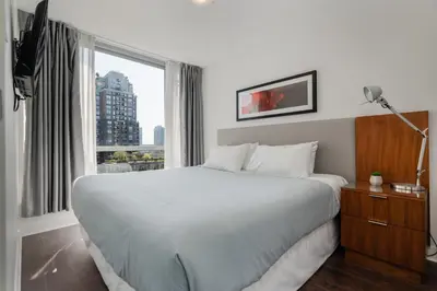 a bedroom with a large white bed and a window at Level Vancouver Yaletown Seymour in Vancouver