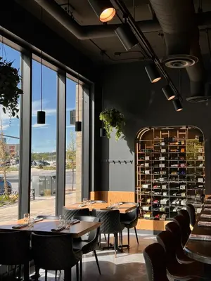 a restaurant with tables and chairs and a wine cellar at Alt Hotel Calgary University District in Calgary