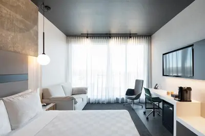 a hotel room with a bed and a desk and a couch at Alt Hotel Calgary University District in Calgary