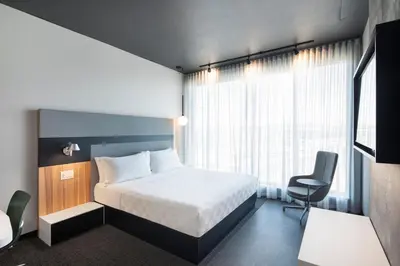 a hotel room with a bed and a chair at Alt Hotel Calgary University District in Calgary