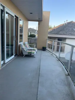 a patio with two lounge chairs on a balcony at Panoramic Ocean View in Nanaimo