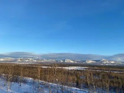 a view of a snowy field with snow covered mountains at Oma's and Opa's Northern Lights Viewing Cabin in Whitehorse