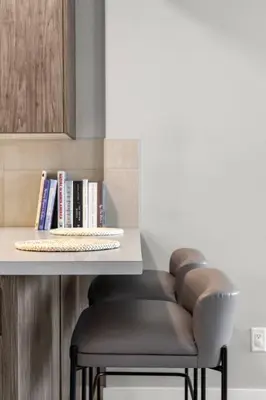 a row of stools sitting under a counter with a table at Modern Basement Gem: 2 BR Retreat in Calgary