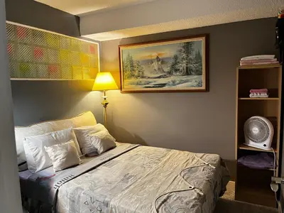 a bedroom with a bed and a painting on the wall at Grie hunting quite room! in Calgary