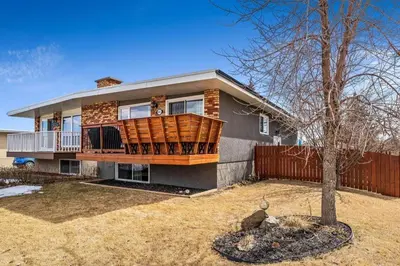 a house with a large deck on the front of it at Grie hunting quite room! in Calgary