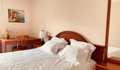 a bedroom with a bed with white sheets and a desk at unit #302 Mountain view 2 beds in DT in Canmore