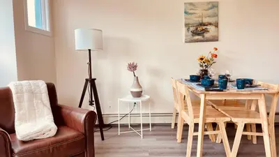 a living room with a dining room table and a chair at unit #302 Mountain view 2 beds in DT in Canmore