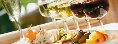a plate of food and wine glasses on a table at Tranquil Retreat Spacious 2-Bedroom on the 2nd Floor in Kelowna