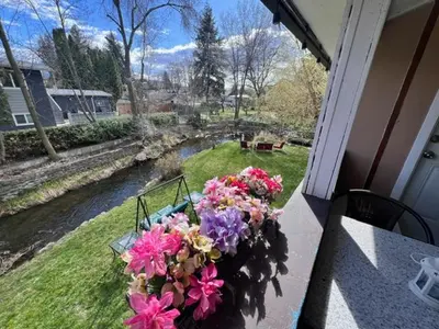 a vase of flowers sitting on a table on a balcony at Kelowna little Island near Downtown, lake, hospital and Okanagan Collage in Kelowna