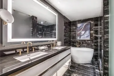 a bathroom with two sinks and a tub and a mirror at AZUR Legacy Collection Hotel in Vancouver