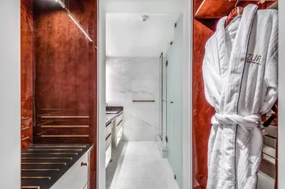 a bathroom with a white robe hanging on a wall at AZUR Legacy Collection Hotel in Vancouver