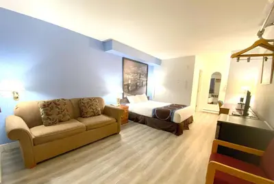 a hotel room with a couch and a bed at Super 8 by Wyndham Sicamous in Sicamous