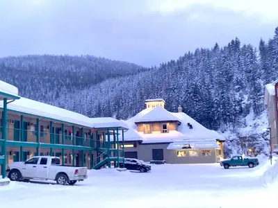 a building in the snow with cars parked in front at Super 8 by Wyndham Sicamous in Sicamous