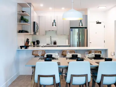 a dining room with a table and chairs and a kitchen at Prime Revy Penthouse in Revelstoke