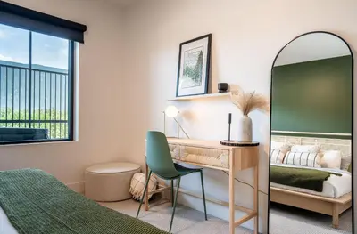 a bedroom with a desk and a bed and a mirror at Prime Revy Penthouse in Revelstoke