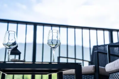 two wine glasses sitting on a table on a balcony at Prime Revy Penthouse in Revelstoke