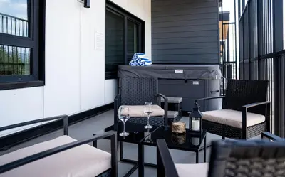 a patio with two chairs and a table on a balcony at Prime Revy Penthouse in Revelstoke
