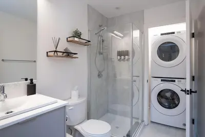 a white bathroom with a washer and dryer at Stoked On Revy - Family Condo in Revelstoke in Revelstoke