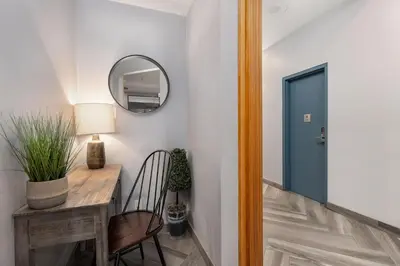 a hallway with a table and a mirror and a chair at Bright Whistler Village Getaway w/ pool & hot tub in Whistler