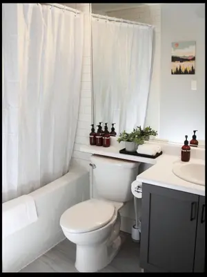 a white bathroom with a toilet and a sink at Bright Whistler Village Getaway w/ pool & hot tub in Whistler
