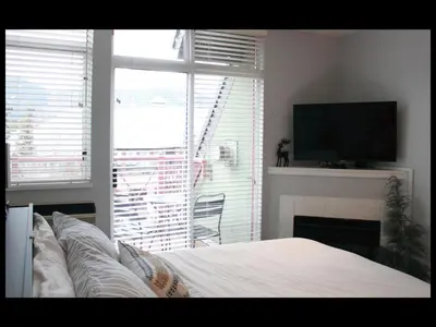 a bedroom with a bed and a fireplace and a television at Bright Whistler Village Getaway w/ pool & hot tub in Whistler