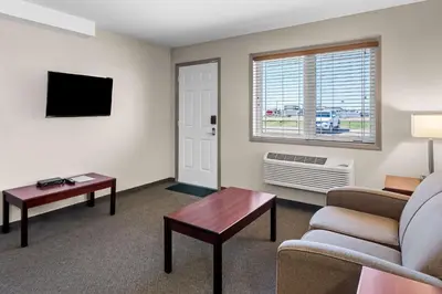 a living room with a couch and a table and a tv at SureStay Hotel by Best Western Bassano in Bassano