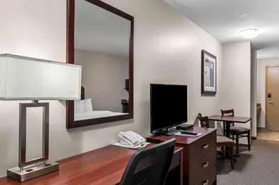 a room with a desk with a computer and a mirror at SureStay Hotel by Best Western Bassano in Bassano