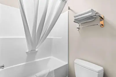 a white bathroom with a shower curtain and a toilet at SureStay Hotel by Best Western Bassano in Bassano