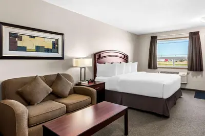 a hotel room with a bed and a couch at SureStay Hotel by Best Western Bassano in Bassano
