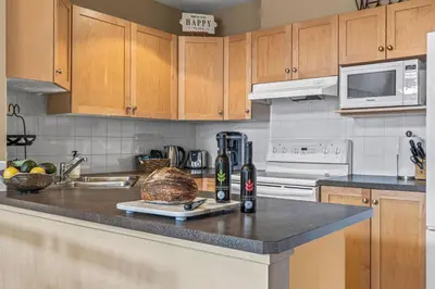 a kitchen with a counter with a loaf of bread on it at Top Floor Wolf - Best Views With Pool and Hot tub in Canmore