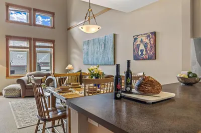 a kitchen with a counter with a bottle of wine on it at Top Floor Wolf - Best Views With Pool and Hot tub in Canmore