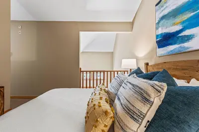 a bedroom with a bed with blue pillows at Top Floor Wolf - Best Views With Pool and Hot tub in Canmore