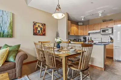 a kitchen and dining room with a table and chairs at Top Floor Wolf - Best Views With Pool and Hot tub in Canmore