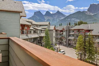 a view from a balcony of a town with mountains at Top Floor Wolf - Best Views With Pool and Hot tub in Canmore