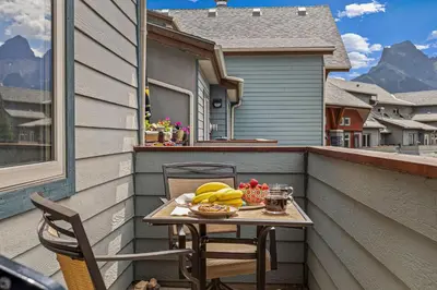 a table on a balcony with a plate of fruit at Top Floor Wolf - Best Views With Pool and Hot tub in Canmore