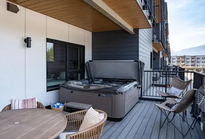 a patio with a grill and tables on a balcony at Ghost Peak by Revelstoke Vacations in Revelstoke