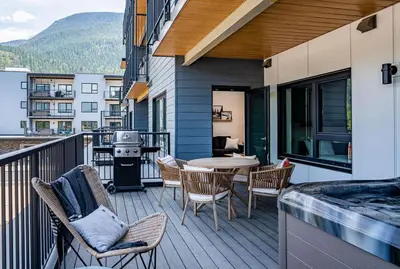 a balcony with a table and chairs and a grill at Ghost Peak by Revelstoke Vacations in Revelstoke