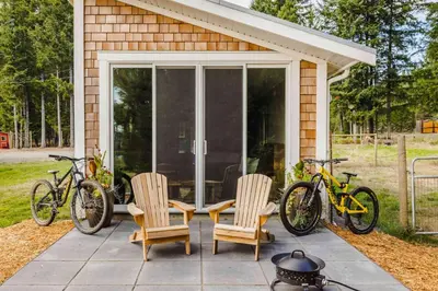 a patio with two chairs and two bikes on it at Tiny house & Sauna on Lakefront Farm Oasis in Merville