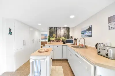 a kitchen with white cabinets and a counter top at Gulf Island View Suite by EMR Vacation Rentals in Chemainus